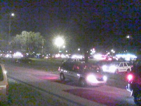 1986 Ford Bronco - Multiple vehicles are visible on a street at night under artificial lighting.
