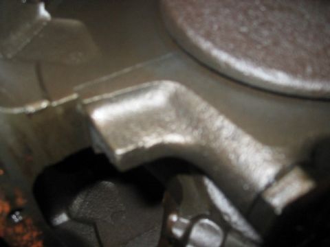 1978 Ford Bronco - A detailed view of a cast metal engine part, showing its industrial texture and form.