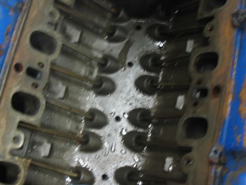 1978 Ford Bronco - Close-up view of an engine's cylinder head, showing internal components and fluid residue.