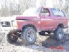 1978 Ford Bronco - This red 1978 Ford Bronco features a lifted suspension and off-road tires, captured in a 3/4 front view.
