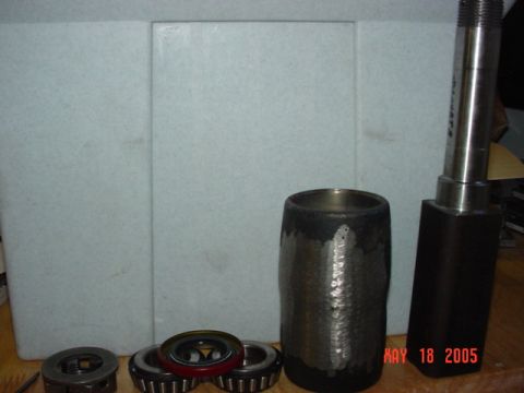 1978 Ford Bronco - Various metal components and bearings are laid out on a wooden surface with a white background.
