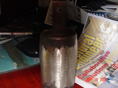 1978 Ford Bronco - A metal object with a textured cylindrical body and a dark rectangular handle is visible on a desk.