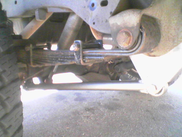 Close-up of a vehicle's leaf spring suspension and tire