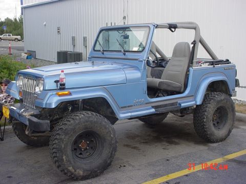 1976 Jeep CJ7 - Blue Jeep Wrangler parked outdoors, showing its side profile and interior.