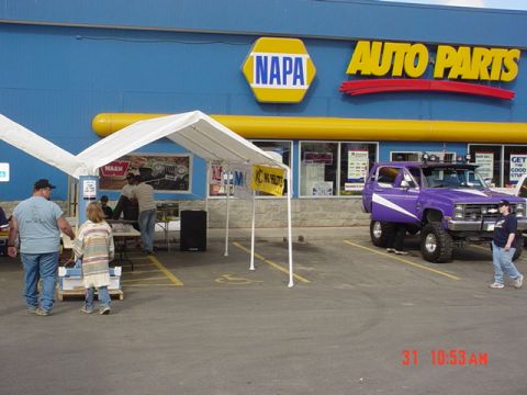 1976 Jeep CJ7 - Modified SUV with custom paint and lift kit outside a NAPA Auto Parts store.