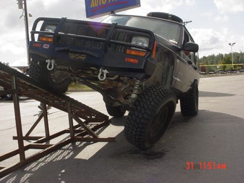 1976 Jeep CJ7 - Modified Jeep Cherokee XJ on a ramp, likely for off-road or display purposes.