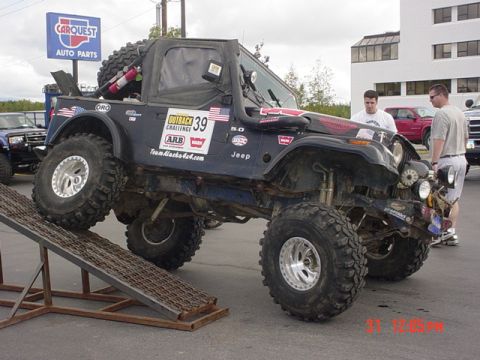 1976 Jeep CJ7 - Modified Jeep CJ with large tires and off-road accessories is positioned on a ramp.