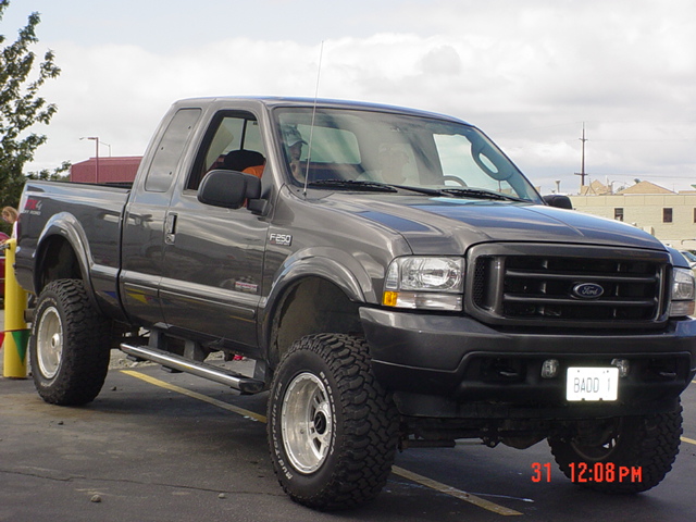 Gray Ford F-250 pickup truck with lifted suspension and custom license plate