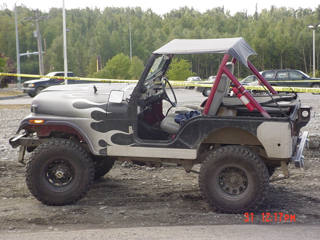 Jeep CJ with flame decals and a soft top. Has a fire extinguisher mounted inside