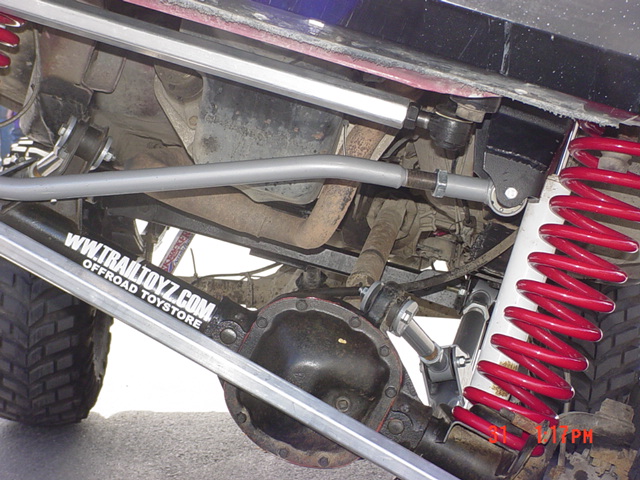 Undercarriage with red coilover shocks and Trail Toyz sticker. No year visible