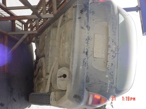 1976 Jeep CJ7 - A dusty Hyundai Elantra is seen upside down, revealing its undercarriage and rear end.