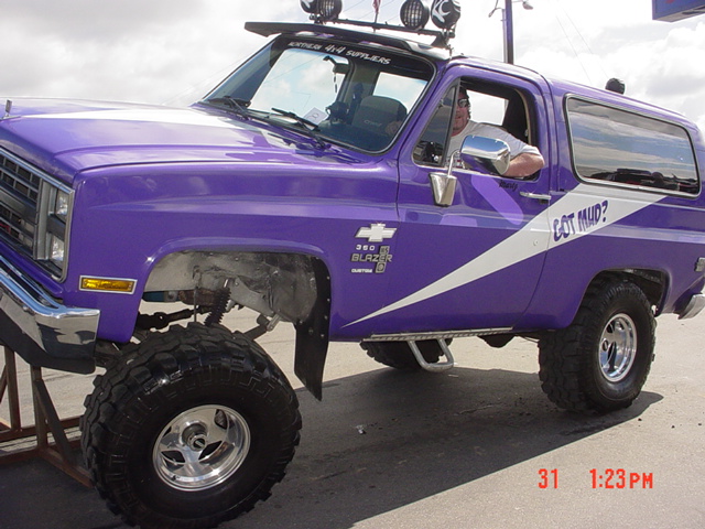 Purple lifted Chevy K5 Blazer with "Got Mud?" graphic and roof lights