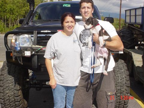 1976 Jeep CJ7 - A family poses with their heavily modified black SUV, a snorkel and massive off-road tires.