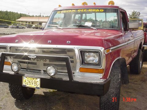 1976 Jeep CJ7 - This red Ford pickup truck features a prominent grille and "KODIAK OFF-ROAD" decal on the windshield.
