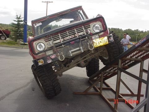 1976 Jeep CJ7 - Ford Bronco attempting an obstacle on a metal ramp.