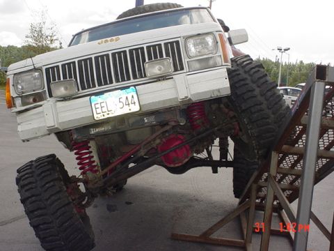 1976 Jeep CJ7 - A modified Jeep Cherokee XJ is positioned on a metal ramp, its off-road capabilities.