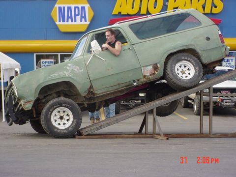 1976 Jeep CJ7 - Green SUV on a ramp in front of a NAPA Auto Parts store.