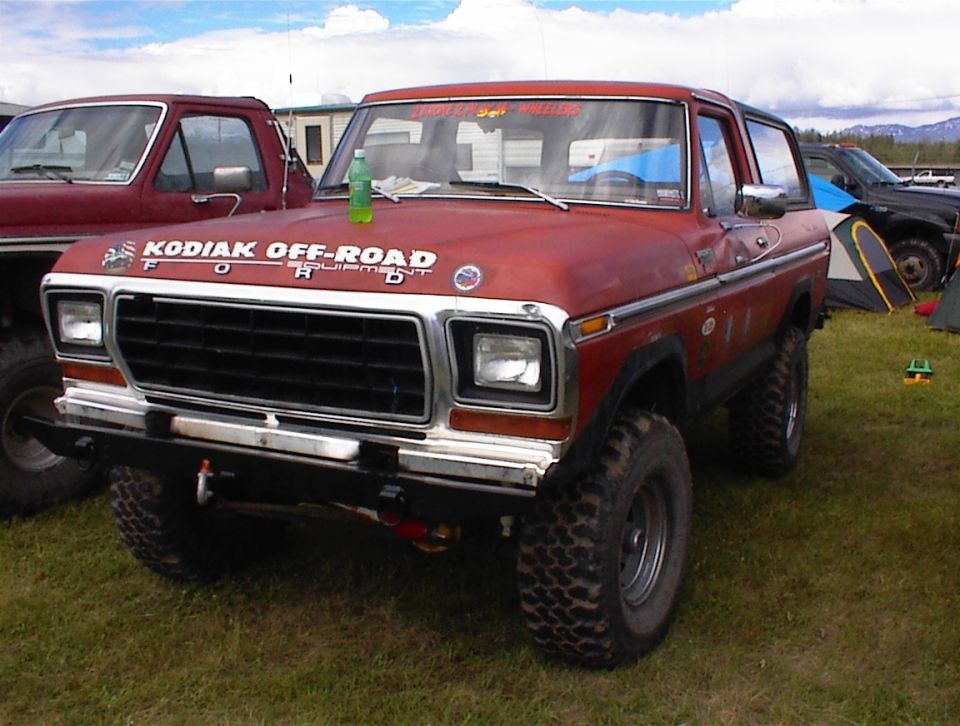 Red 1978 Ford Bronco with "KODIAK OFF-ROAD EQUIPMENT" decals on the hood, parked on grass