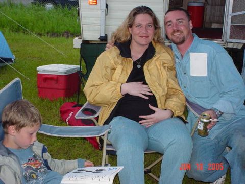 1978 Ford Bronco - Family enjoys an outdoor gathering at a campsite with a trailer in the background.