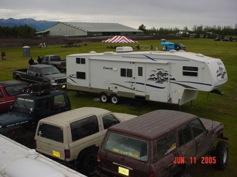 1978 Ford Bronco - Several vehicles are parked on a grassy field, including a tan Ford Bronco and a large RV.