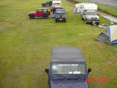 1978 Ford Bronco - A gathering of off-road vehicles and campers are seen in a grassy field, possibly at an event or campsite.