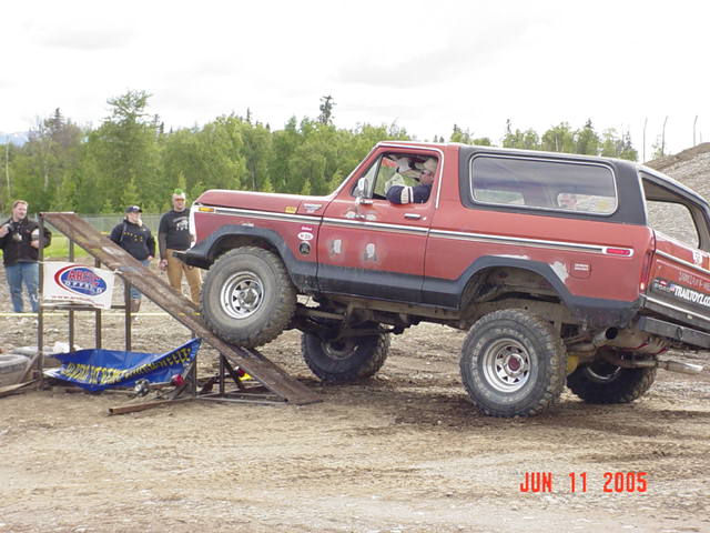 Red 1978 Ford Bronco on a ramp with off-road tires