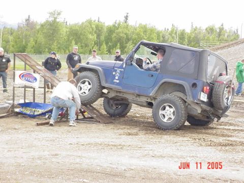 1978 Ford Bronco - A blue Jeep Wrangler navigates an obstacle course ramp during an event in 2005.