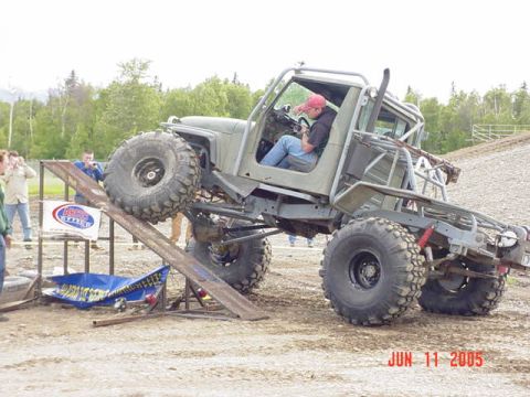 1978 Ford Bronco - A heavily modified off-road vehicle navigates an obstacle course, with spectators watching.