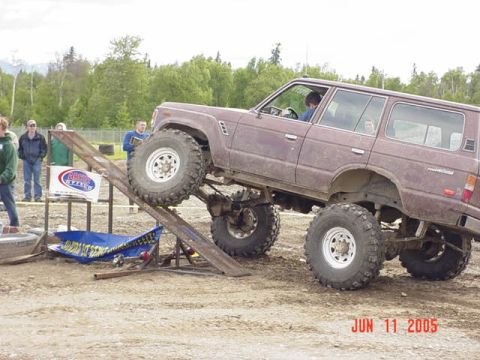 1978 Ford Bronco - This modified SUV is attempting to climb a ramp at an outdoor event.