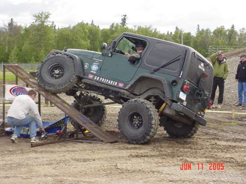 1978 Ford Bronco - A Jeep navigates an obstacle during an off-road event.