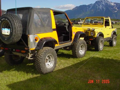 1978 Ford Bronco - Two Suzuki Samurai SUVs are parked on a grassy field with mountains in the distance. A date stamp reads JUN 11 2005.
