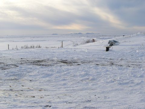 2001 Jeep Wrangler - A trailer rests in a snow-covered landscape under a cloudy sky.
