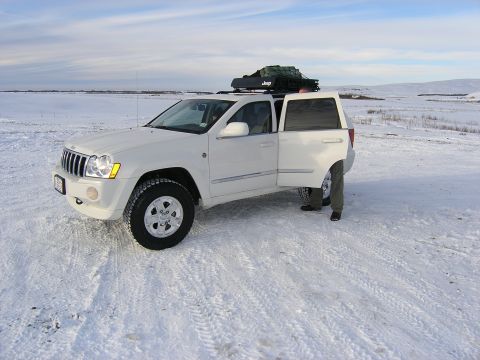 2001 Jeep Wrangler - A white Jeep Grand Cherokee is parked in a snowy field with its doors open and a loaded roof rack.