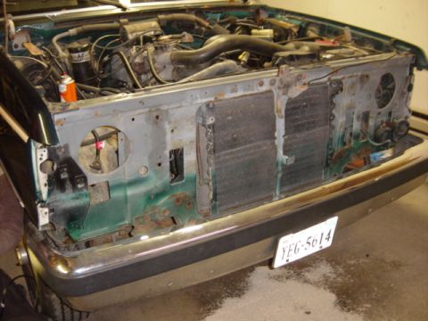 1991 Ford Bronco - The front of a green 1991 Ford Bronco is shown with its engine and radiator exposed, indicating disassembly.