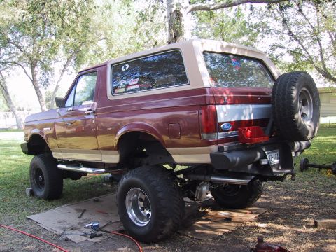 1990 Ford Bronco - This lifted Ford Bronco is parked outdoors with tools scattered around its rear tires.