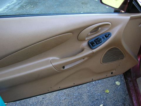 1994 Ford Probe - The tan interior door panel features power window controls and a speaker grille.