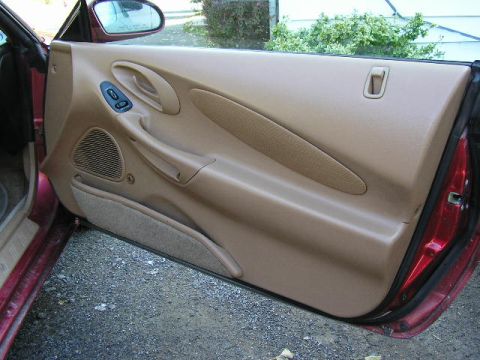 1994 Ford Probe - Interior view of a car's driver side door panel, showing tan trim and controls.