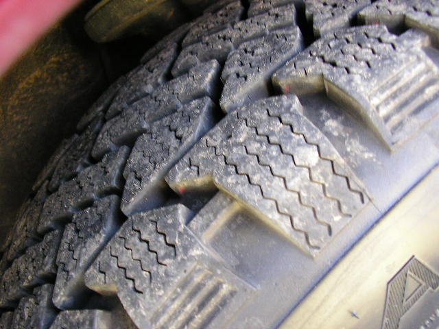Close-up of a tire tread with Supermotors.net logo visible