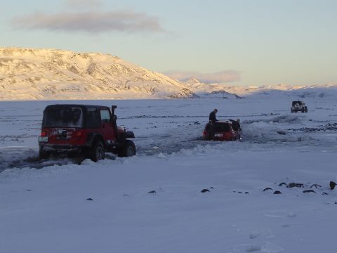 2001 Jeep Wrangler - Several vehicles navigate a snowy landscape with mountains in the background.