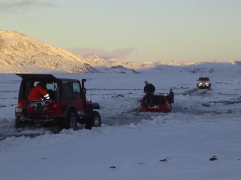 2001 Jeep Wrangler - Multiple Jeeps navigate a snowy landscape, with one red SUV partially submerged in snow.