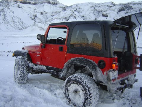 2001 Jeep Wrangler - Red 2001 Jeep TJ Wrangler parked in a snowy landscape with mountains in the background.