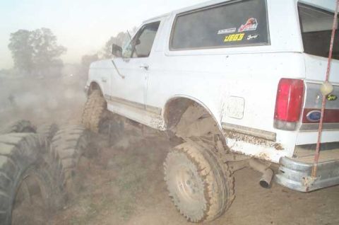 1988 Ford Bronco - This 1988 Ford Bronco is shown off-roading with large tires kicking up dust.