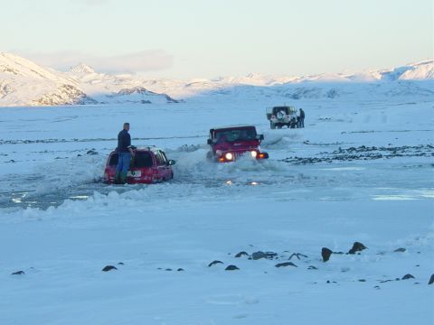 2001 Jeep Wrangler - Multiple Jeeps navigate a snowy, watery terrain with a person standing on a red SUV.