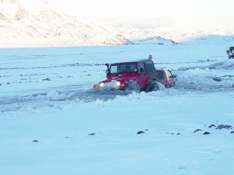 2001 Jeep Wrangler - A red 2001 Jeep TJ navigates a snowy, watery terrain with another vehicle following closely.