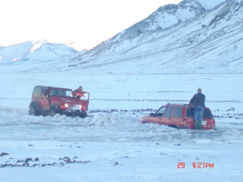 2001 Jeep Wrangler - Two vehicles are stuck in a snowy landscape with people attempting to free them.