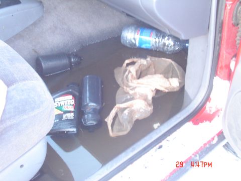 2001 Jeep Wrangler - The floor of the vehicle's interior is wet, with various items scattered around.
