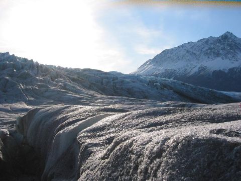 1993 Ford Bronco - A vast glacier stretches towards snow-covered mountains under a bright, sunlit sky.
