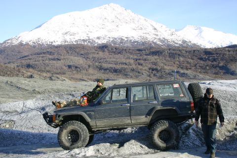 2003 Jeep TJ - A modified Jeep Cherokee XJ is parked on a glacier with a snowy mountain range in the background.