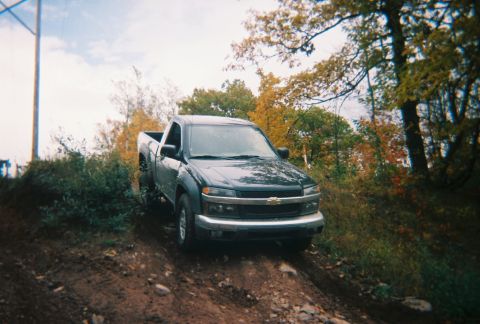 2000 Chevrolet Tahoe - A Chevrolet Colorado pickup truck navigates a dirt trail surrounded by autumn foliage.