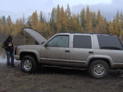 2000 Chevrolet Tahoe - Silver 2000 Chevrolet Tahoe with hood open, parked off-road in autumn.
